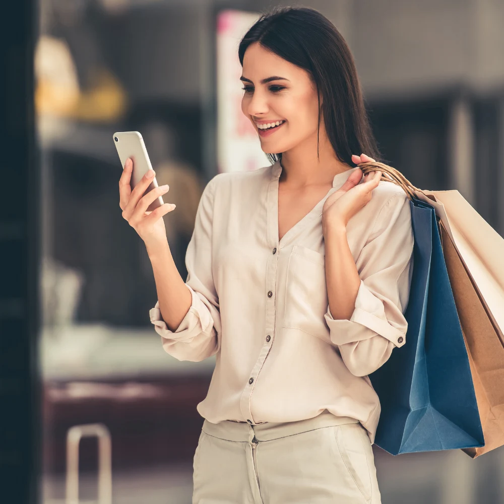 Girl receiving a text while shopping, letting her know her table is ready at your restaurant.