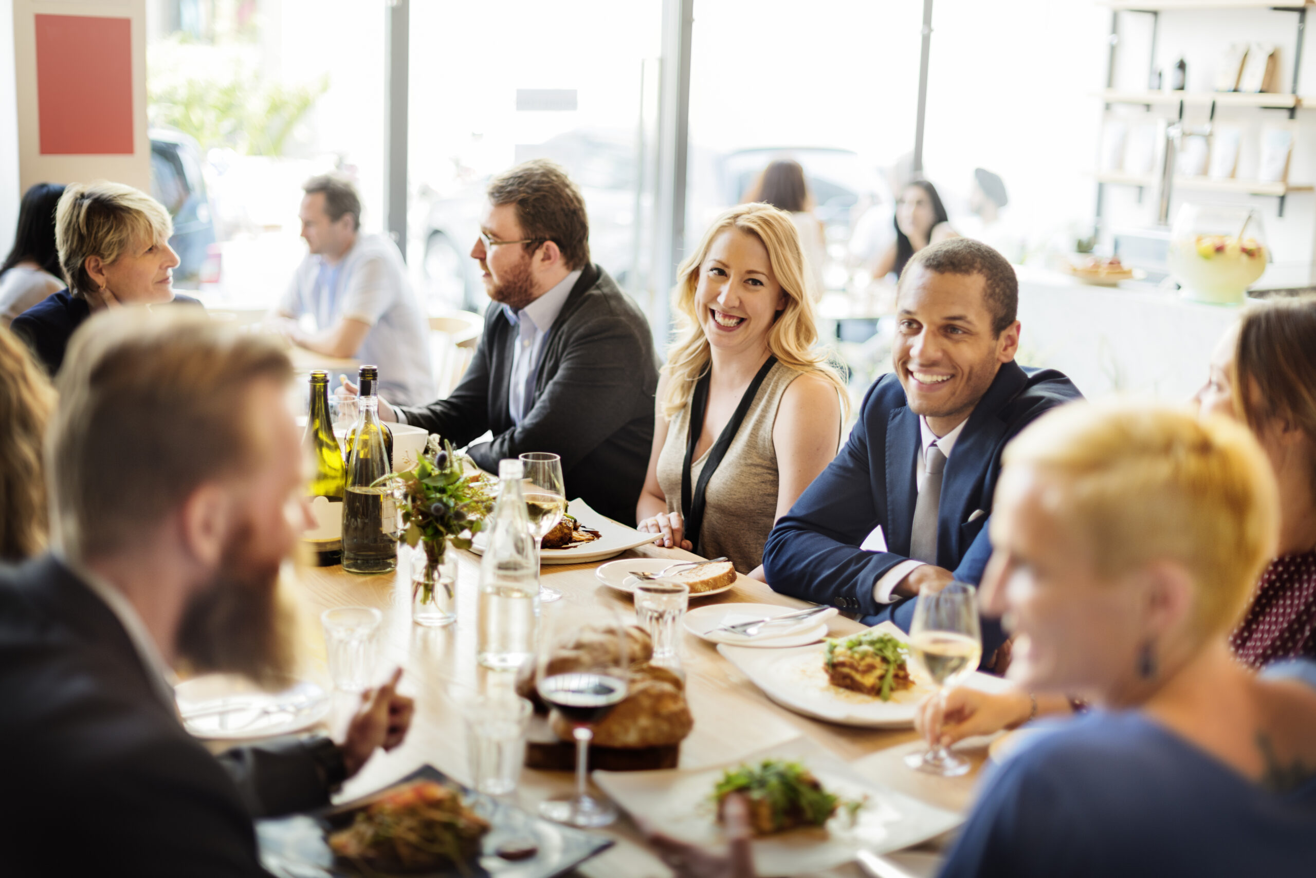 Large group of business guests dining together at a restaurant table